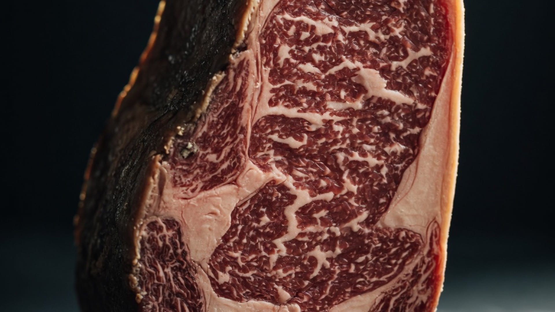A thick dry-aged ribeye steak with dense white marbling